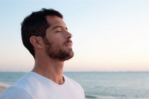Mind Your Body Co - Man deep breathing in front of ocean